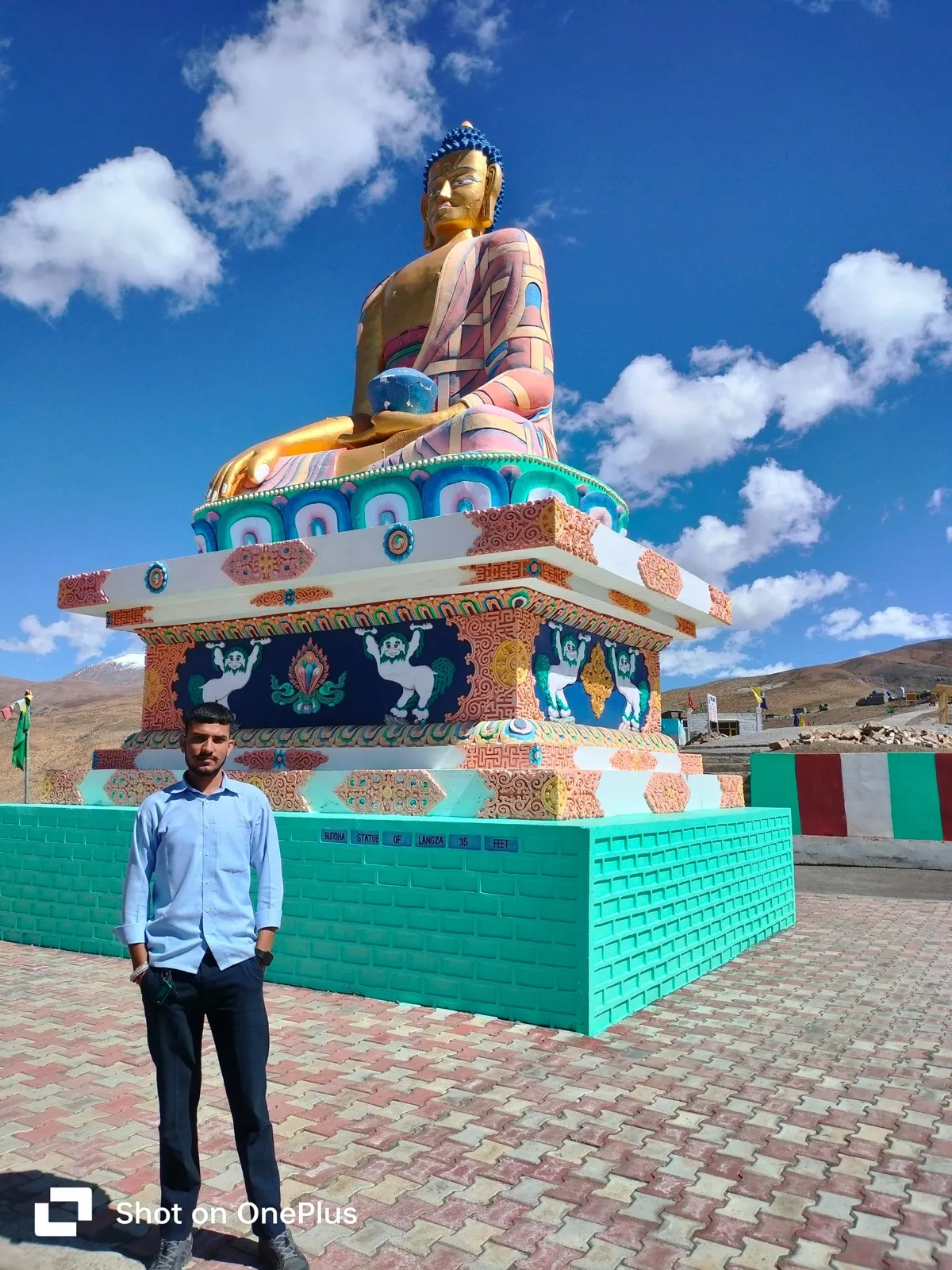 Kulwant standing beside the 35-foot Buddha statue at Langza