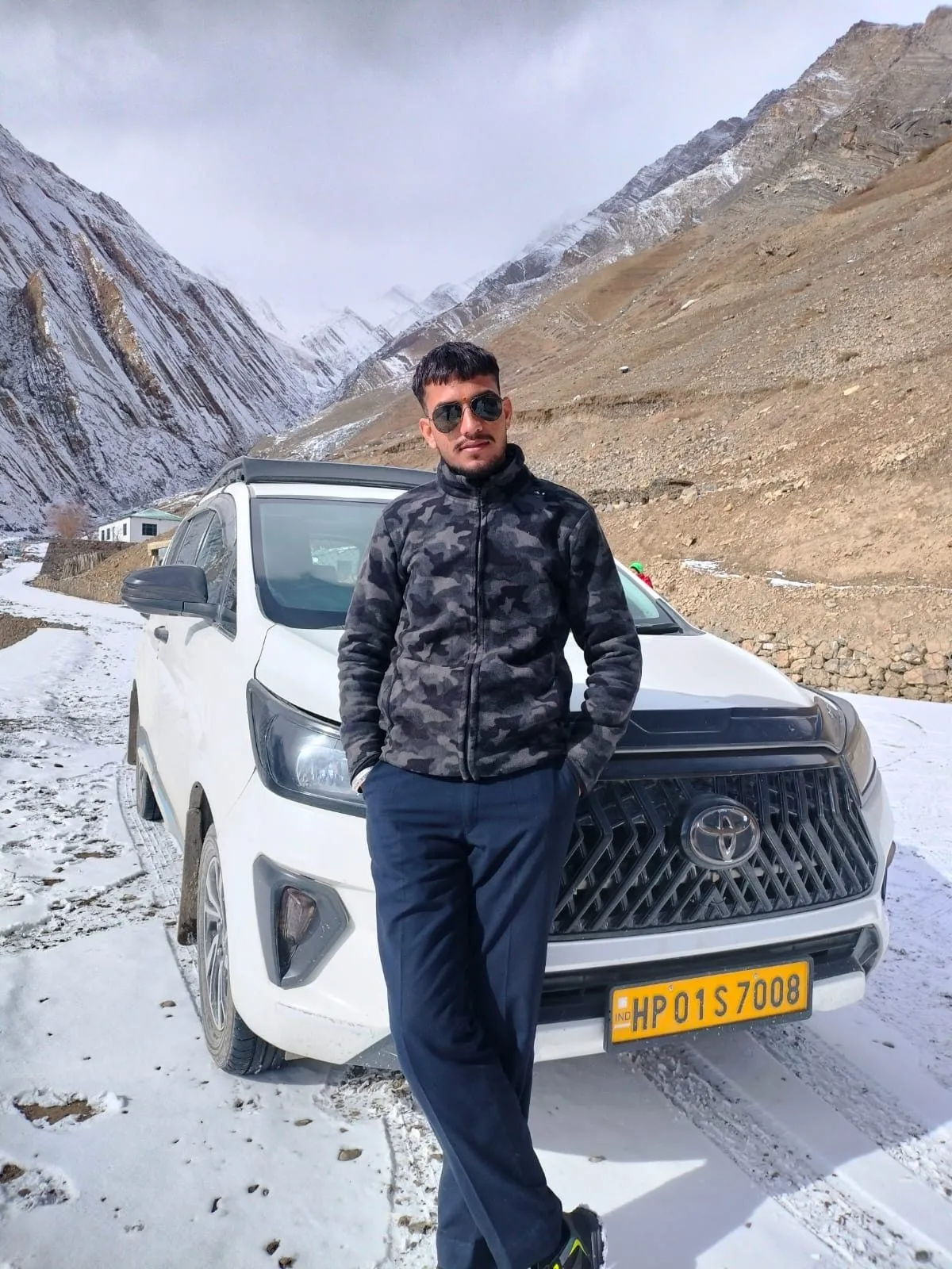 Kulwant beside his SUV on the snow-covered road near Losar