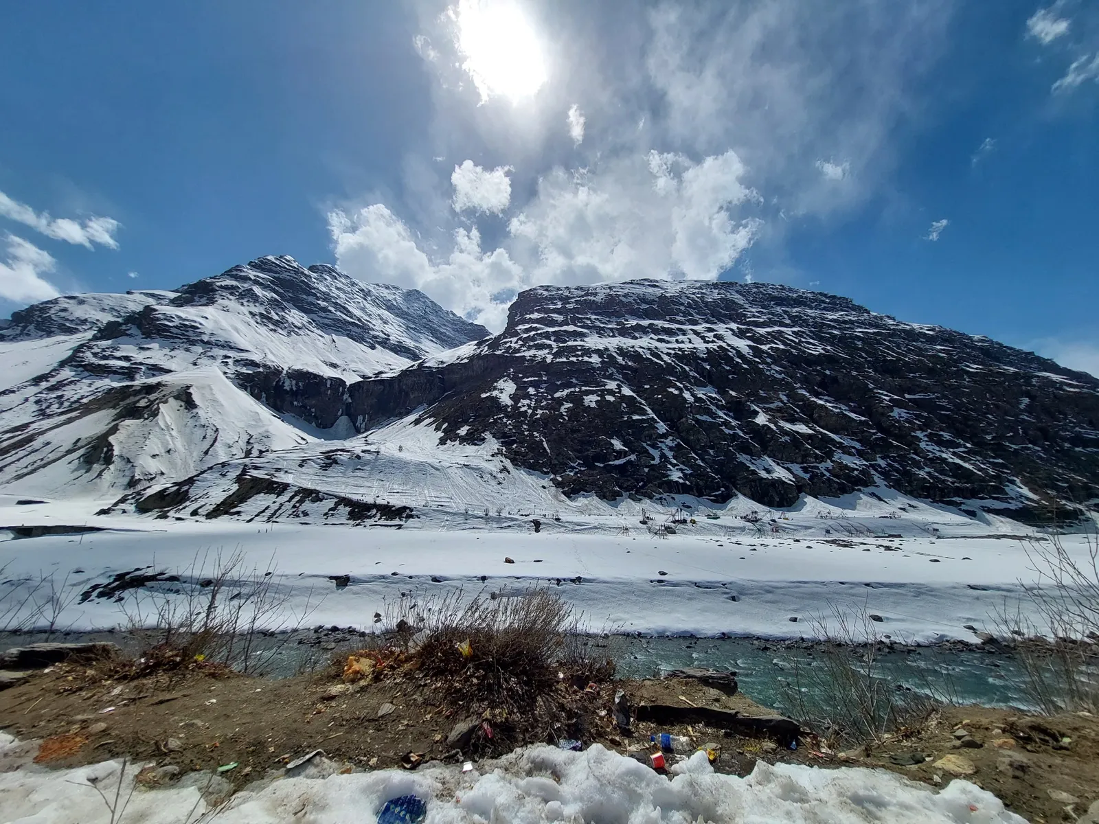 A snow-covered mountain with ski-slope equipment visible at its base