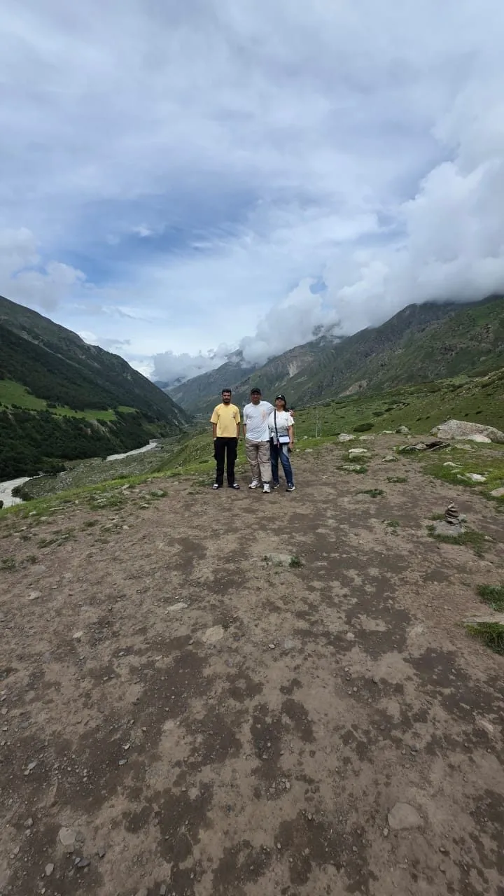A group of travelers standing together in the green valley near Chitkul